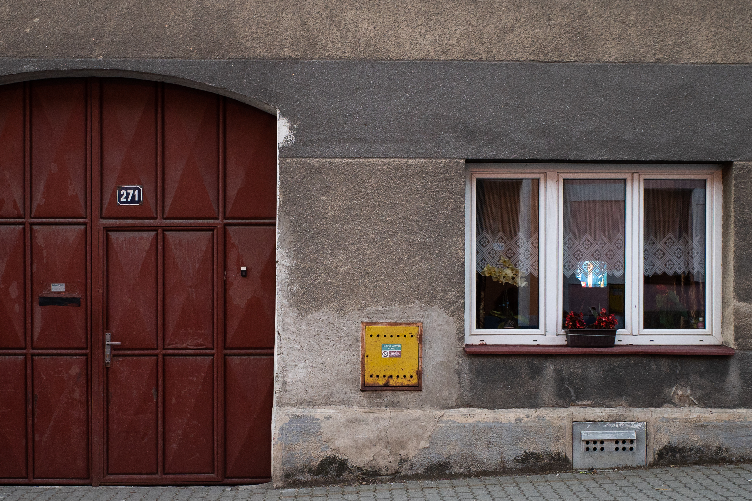 Nummer 271: rotes Tor, Spitzengardine, Geranien am Fensterbrett